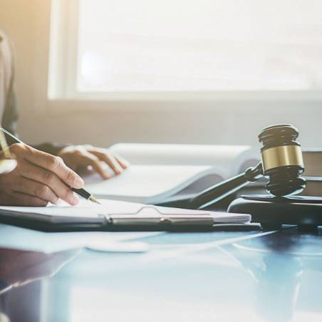 Person with Pen in hand next to a Gavel
