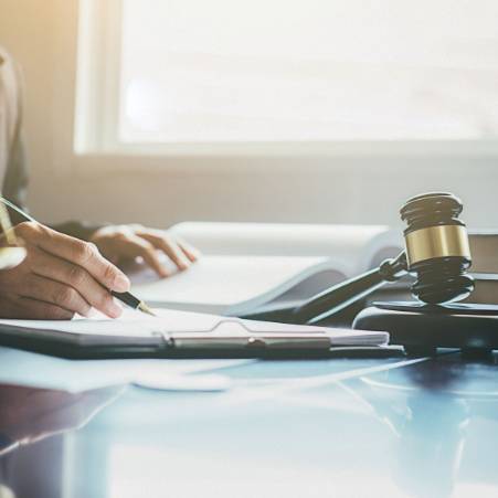 Person with Pen in hand next to a Gavel